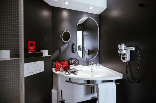 a bathroom with a white sink and a mirror at Ibis Luxembourg Airport in Luxembourg