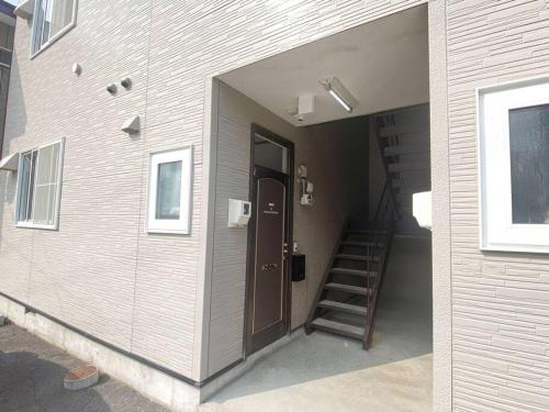 a building with a door and a staircase in it at Tasogare Apartment 101 in Hakodate
