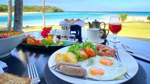 uma mesa com um prato de comida de café da manhã e a praia em InterContinental Fiji Golf Resort & Spa by IHG em Natadola