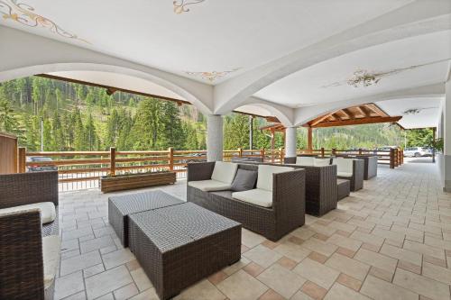 an outdoor patio with couches and chairs on a deck at Aparthotel Princess in Canazei