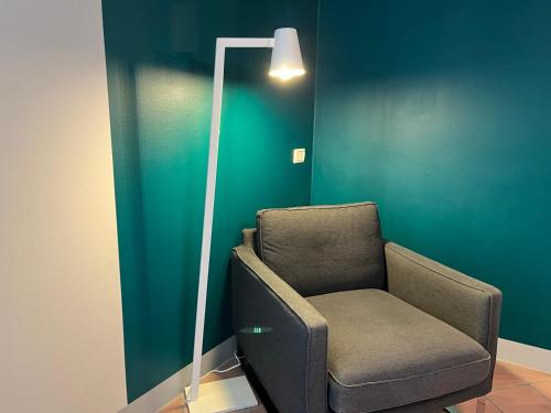 a chair in a room with a green wall at PortAllegra Charme&Relax in Bergamo