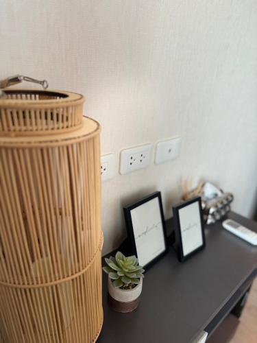a desk with two pictures and a plant on it at The Base Condo in Pattaya Central