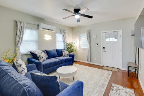 a living room with blue couches and a ceiling fan at Hot Springs Home with Yard, Walk to Bathhouse Row! in Hot Springs
