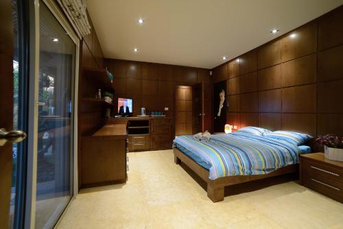 a bedroom with a bed and a desk and a television at La Villa Eilat in Eilat