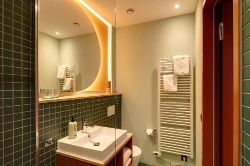 a bathroom with a sink and a mirror at DEIN APART München in Munich