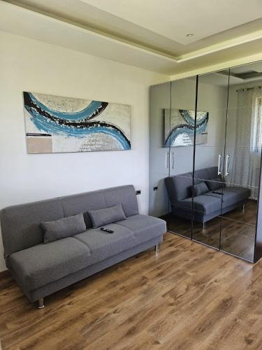 a living room with a couch and a glass wall at San Fedele Intelvi - Starsirius Apartments in San Fedele Intelvi