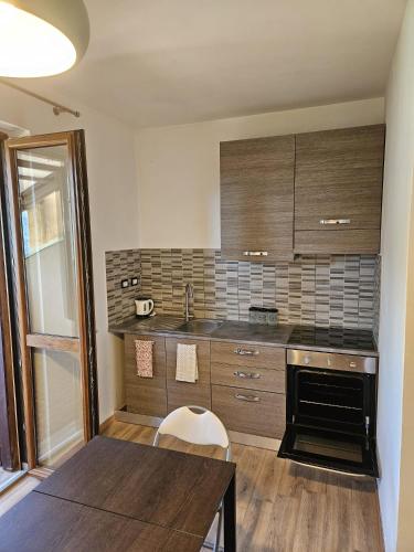a kitchen with a table and a sink and a stove at San Fedele Intelvi - Starsirius Apartments in San Fedele Intelvi