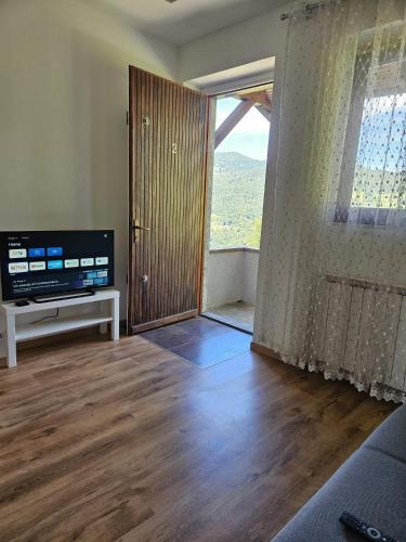a living room with a sliding door and a television at San Fedele Intelvi - Starsirius Apartments in San Fedele Intelvi