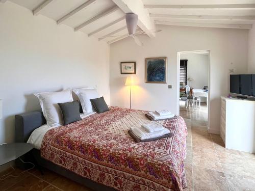 une chambre avec un grand lit et une télévision dans l'établissement Le Clos de Yann, à Gordes