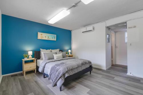Un dormitorio con una pared azul y una cama. en The mariner Suites #22 - Beachfront Studio, en Hollywood