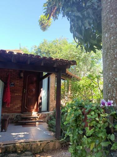 a small brick house with a door in a yard at Pousada Alfa e Ômega in Alto Paraíso de Goiás
