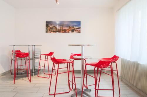 - un ensemble de tabourets de bar rouges dans une pièce dans l'établissement {La Parenthèse Heureuse}, proche Bâle, Rhin, Forêt, à Kembs