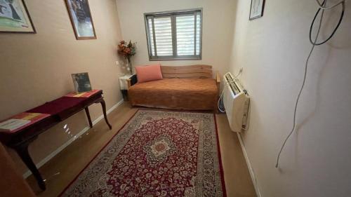 a small room with a bed and a window at קוט'ג 6 חדרים שלווה תבורית in Kefar Tavor