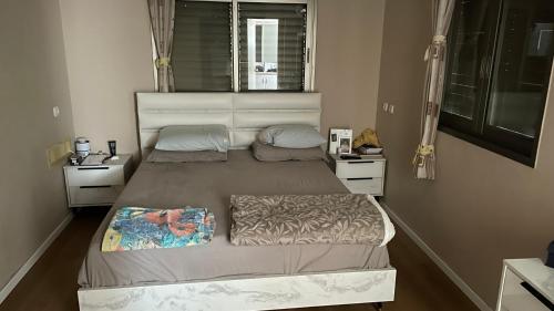 a bedroom with two beds and a window at קוט'ג 6 חדרים שלווה תבורית in Kefar Tavor