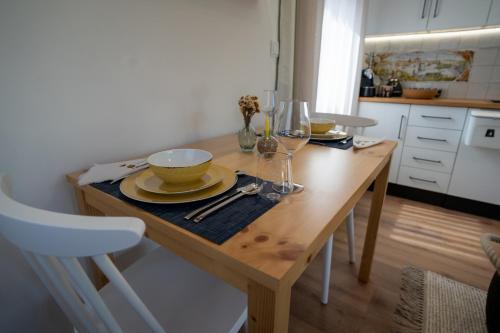 a kitchen with a wooden table with plates and wine glasses at Refúgio da Quinta Nere Maitia in Santarém