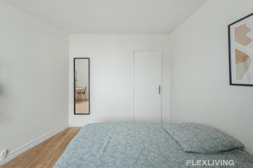 une chambre blanche avec un lit et un miroir dans l'établissement Flexliving - Room - Henri Sellier - Suresnes 92, à Suresnes