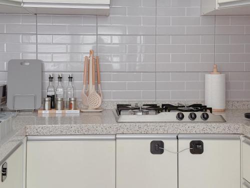a white kitchen with a stove and a counter top at 4 bed 3 room near Gimpo airport in Seoul