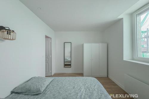 une chambre blanche avec un lit et un miroir dans l'établissement Flexliving - Room - Henri Sellier - Suresnes 92, à Suresnes