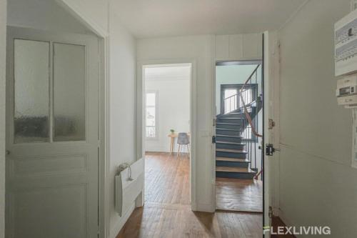 a white hallway with a staircase and a door at Flexliving - Room - Henri Sellier - Suresnes 92 in Suresnes