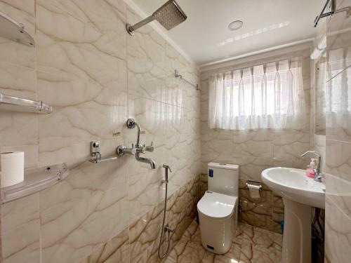 Un baño con ducha, inodoro y lavabo. en Shakya House, en Pātan