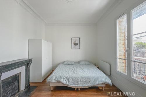 une chambre blanche avec un lit et une cheminée dans l'établissement Flexliving - Room - Henri Sellier - Suresnes 92, à Suresnes