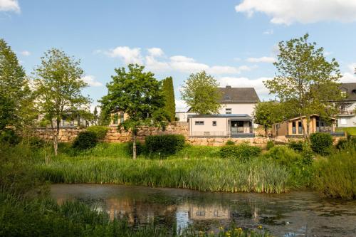 a view of a river with houses in the background at Chalet Bachwies I Terrasse I Seeblick I Wandern in Hillesheim