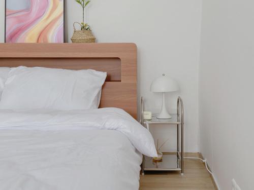 a bedroom with a white bed with a wooden headboard at 4 bed 3 room near Gimpo airport in Seoul