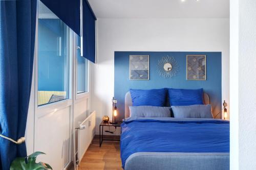 a blue bedroom with a bed with a blue headboard at Ferienwohnung Clara in Bremerhaven