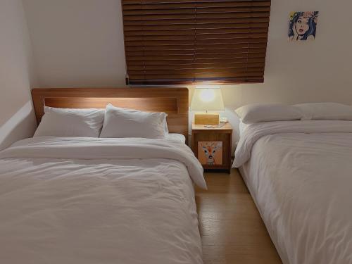 two beds sitting next to each other in a bedroom at 4 bed 3 room near Gimpo airport in Seoul