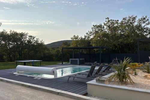 una piscina con sillas y un cenador en Charmante maison a la campagne, en Roussas