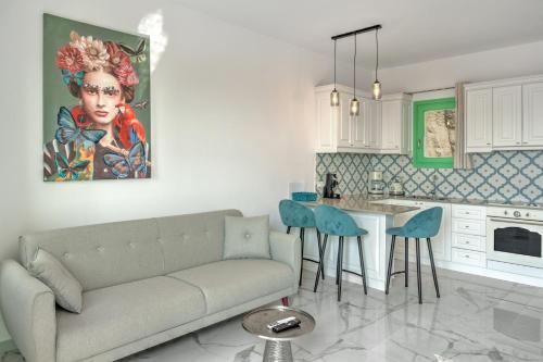 a living room with a couch and a table with chairs at Yani La Scala Luxury Villas in Lefkos Karpathou