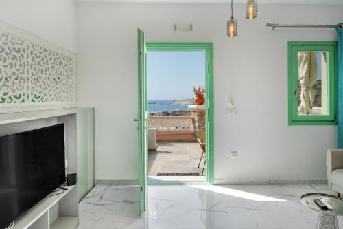 a living room with a door open to a patio at Yani La Scala Luxury Villas in Lefkos Karpathou
