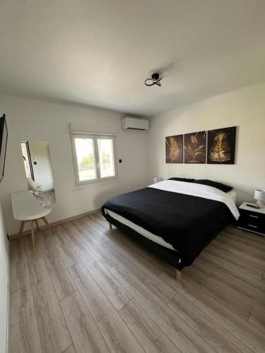 une chambre avec un grand lit et un parquet dans l'établissement Charmante maison a la campagne, à Roussas