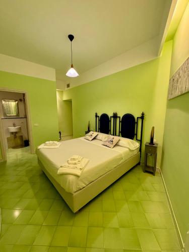 a bedroom with a large bed with green walls at Vesuvio View in Vico Equense
