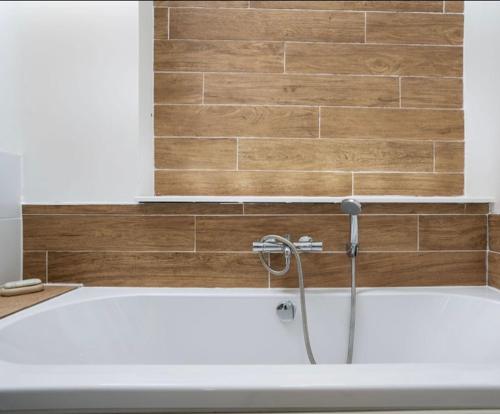 a bath tub with a shower in a bathroom at The old ice cream parlour in Penzance