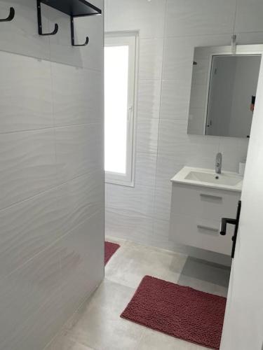 une salle de bain blanche avec une douche et un lavabo dans l'établissement Maison de vacances en bord de mer Gold Beach, à Asnelles