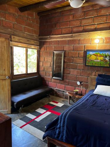 a bedroom with a bed and a brick wall at Hacienda Valencia in Santa Marta