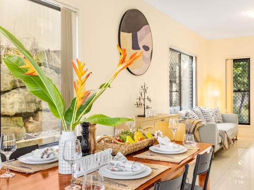 a living room with a dining room table with a vase at 3BD Townhouse close to shops, transport with carpark in Brisbane
