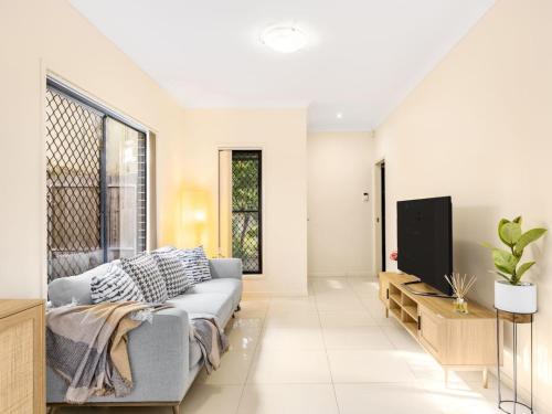 a living room with a couch and a tv at 3BD Townhouse close to shops, transport with carpark in Brisbane