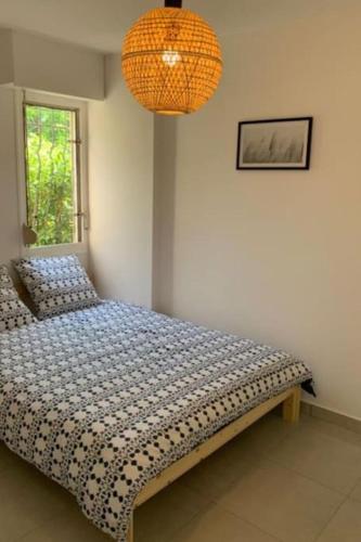 une chambre avec un lit et un lustre dans l'établissement Superbe appartement en résidence, à Sainte-Maxime