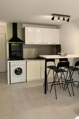 une cuisine avec une table, des chaises et une cuisinière dans l'établissement Superbe appartement en résidence, à Sainte-Maxime