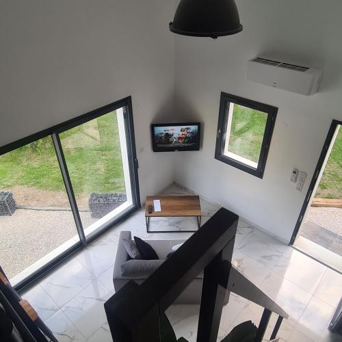 un salon avec un canapé et deux fenêtres dans l'établissement les palmiers de l'isle, à Lagnes