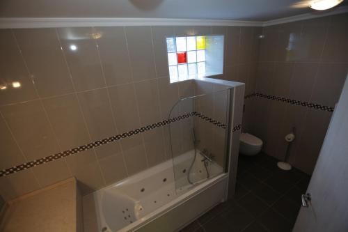 a bathroom with a tub and a toilet and a window at Exclusive new apartment in Tavira in Tavira