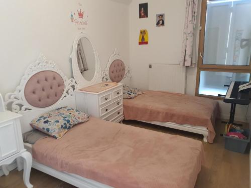 オーベルヴィリエにあるMaison Familiale JO 2024のベッドルーム1室(ベッド2台、ドレッサー、鏡付)