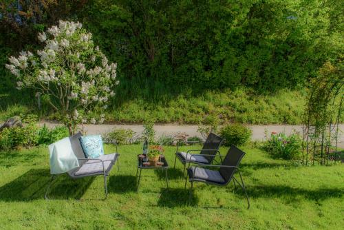 two chairs and a table in a yard at Charming Loft Ferienwohnung Bodensee in Meckenbeuren