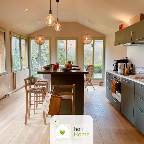 une cuisine avec une table et des chaises dans une pièce dans l'établissement H2 Maison au pied du Château, à Fougères