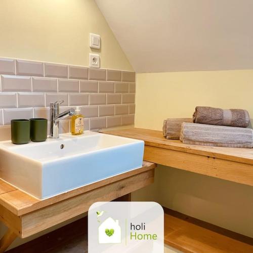 La salle de bains est pourvue d'un lavabo blanc et d'un comptoir. dans l'établissement H2 Maison au pied du Château, à Fougères