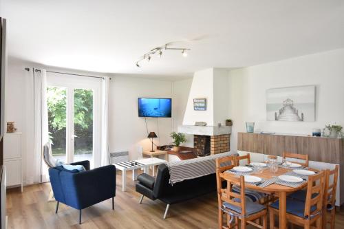 une salle à manger et un salon avec une table et des chaises dans l'établissement Cantegril - Hossegor jolie villa mitoyenne avec jardin clos indépendant idéalement située entre lac et océan, à Soorts-Hossegor