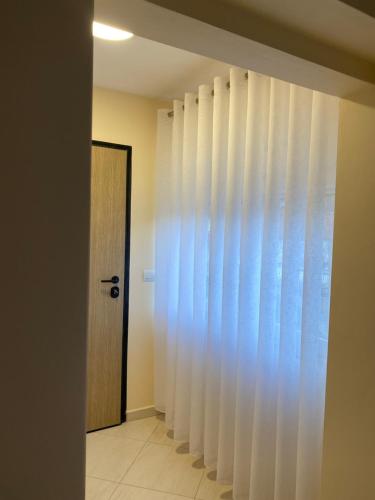 a hallway with white curtains and a door at Vacation Home Ilia in Përmet