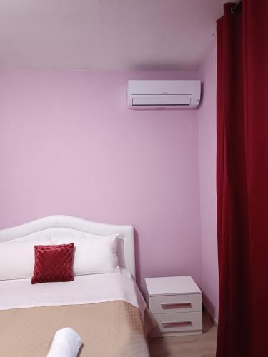 a bedroom with a white bed with a red pillow at Locazione turistica 2 in Tessera
